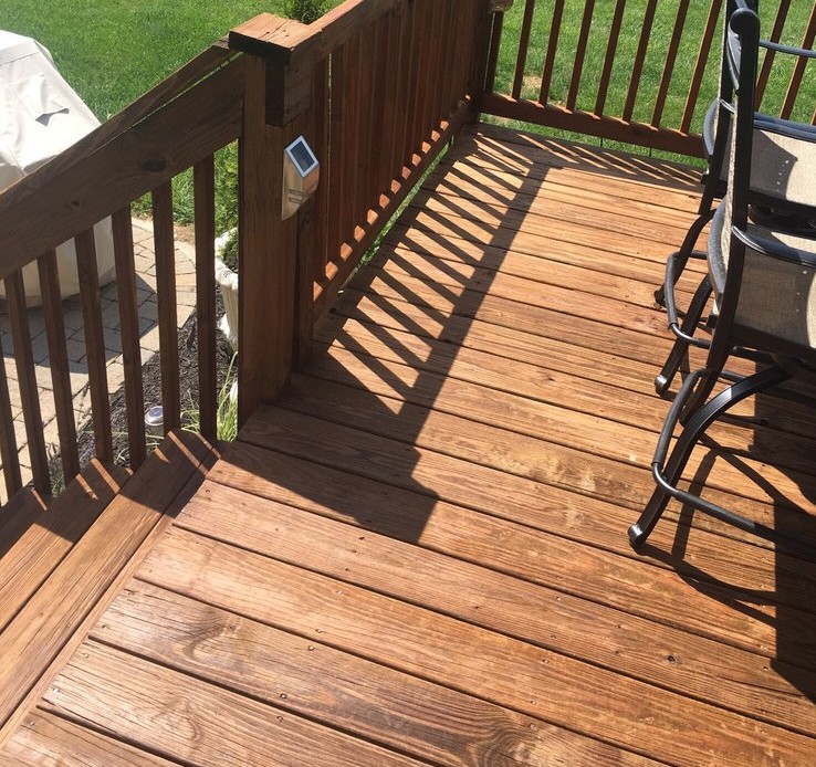 Clean wooden deck with sunlight casting shadows on the surface